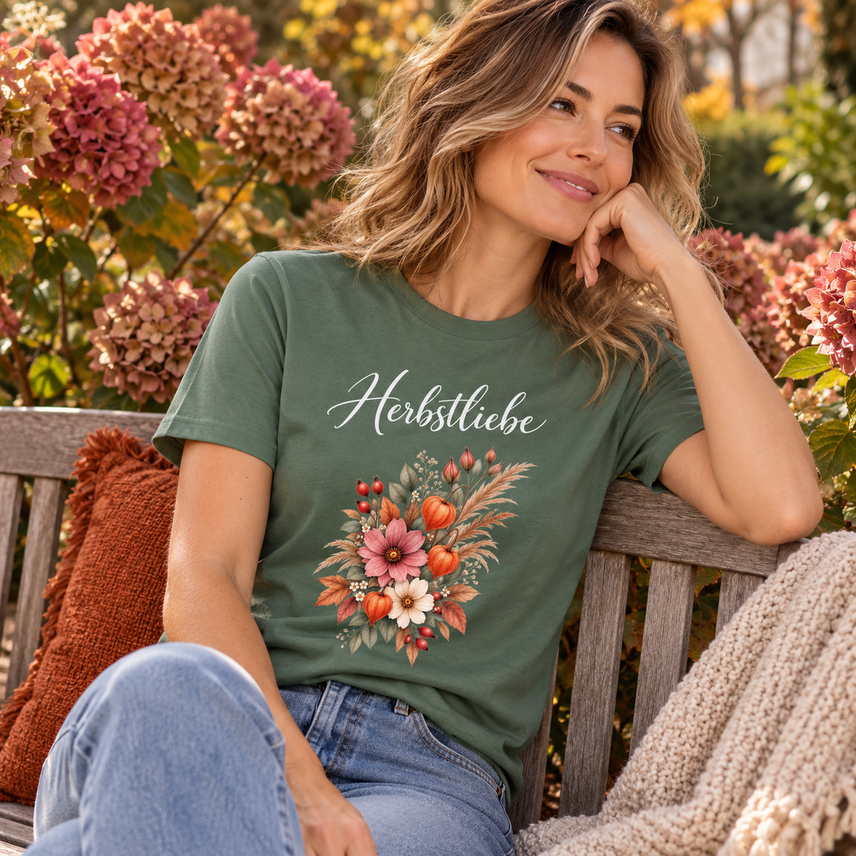 Frau im Autumn Garden Dark Essential T-Shirt auf einer herbstlichen Gartenbank