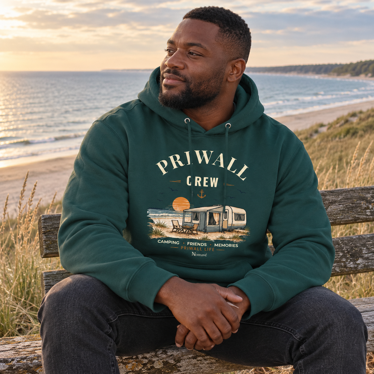 Mann im glazed-grünen Bio Hoodie mit Priwall-Crew-Motiv an der Ostseeküste