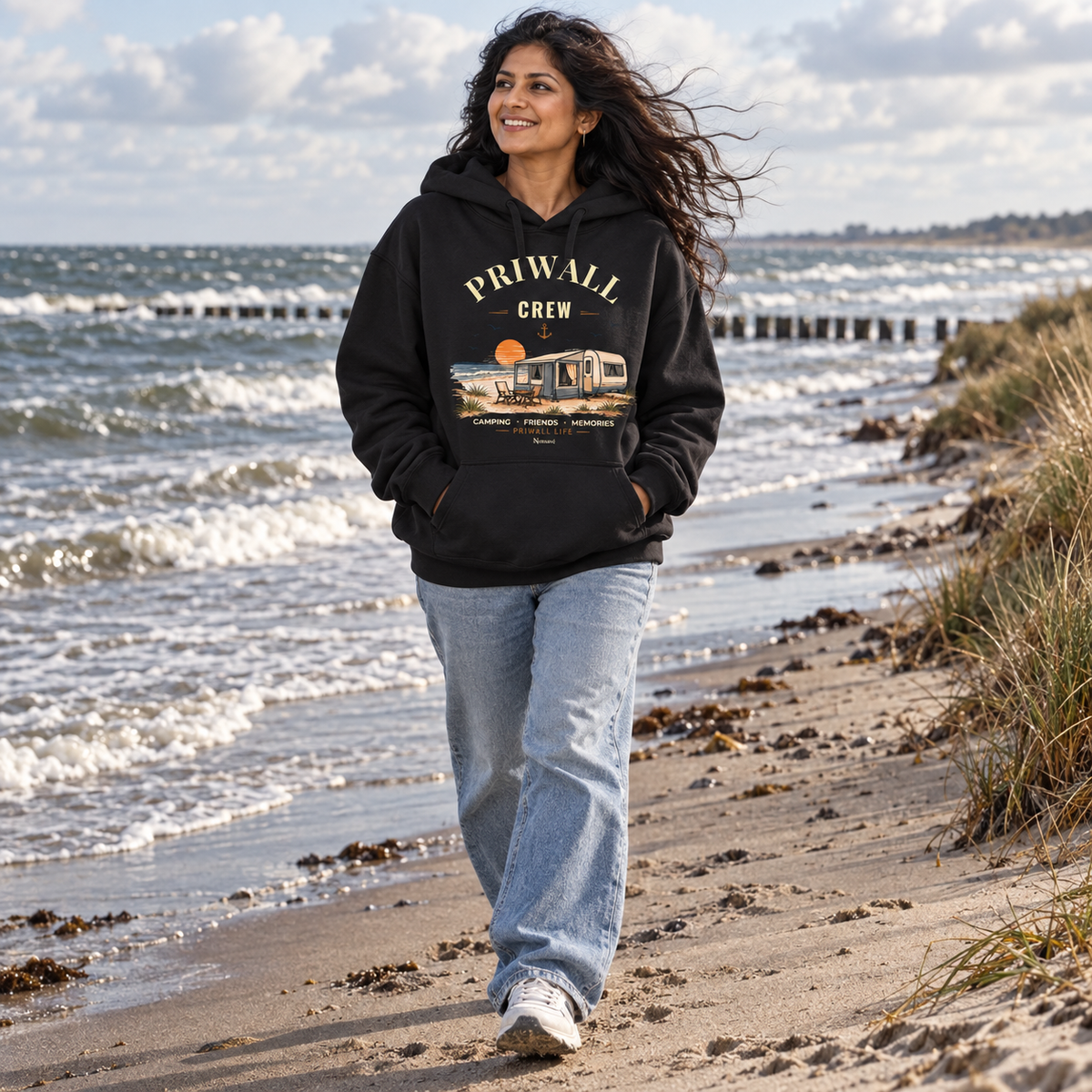 Frau im schwarzen Bio Oversize Hoodie mit Priwall-Crew-Motiv am Ostseestrand