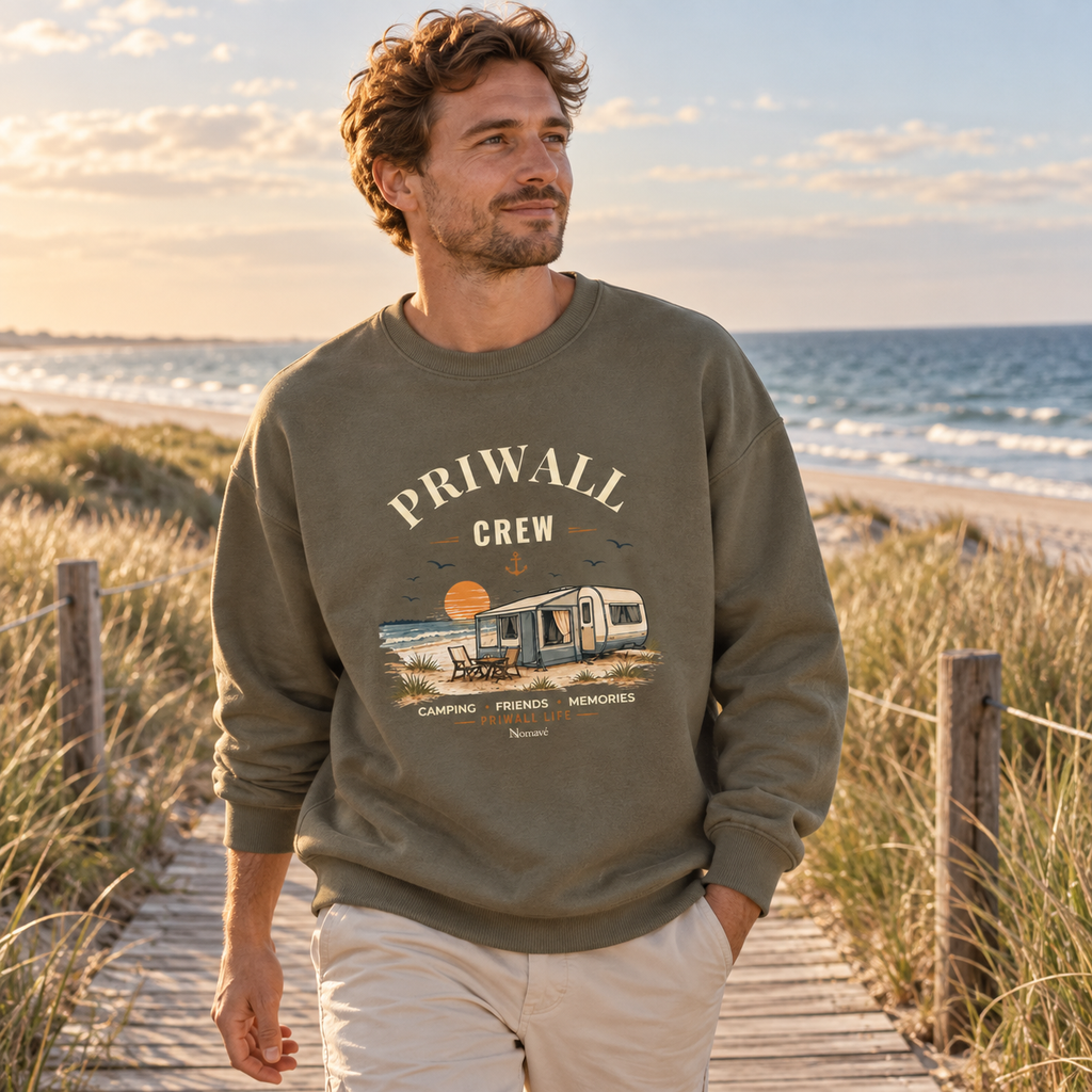Mann im khakifarbenen Bio Oversize Sweatshirt mit Priwall-Crew-Motiv auf einem Dünenweg