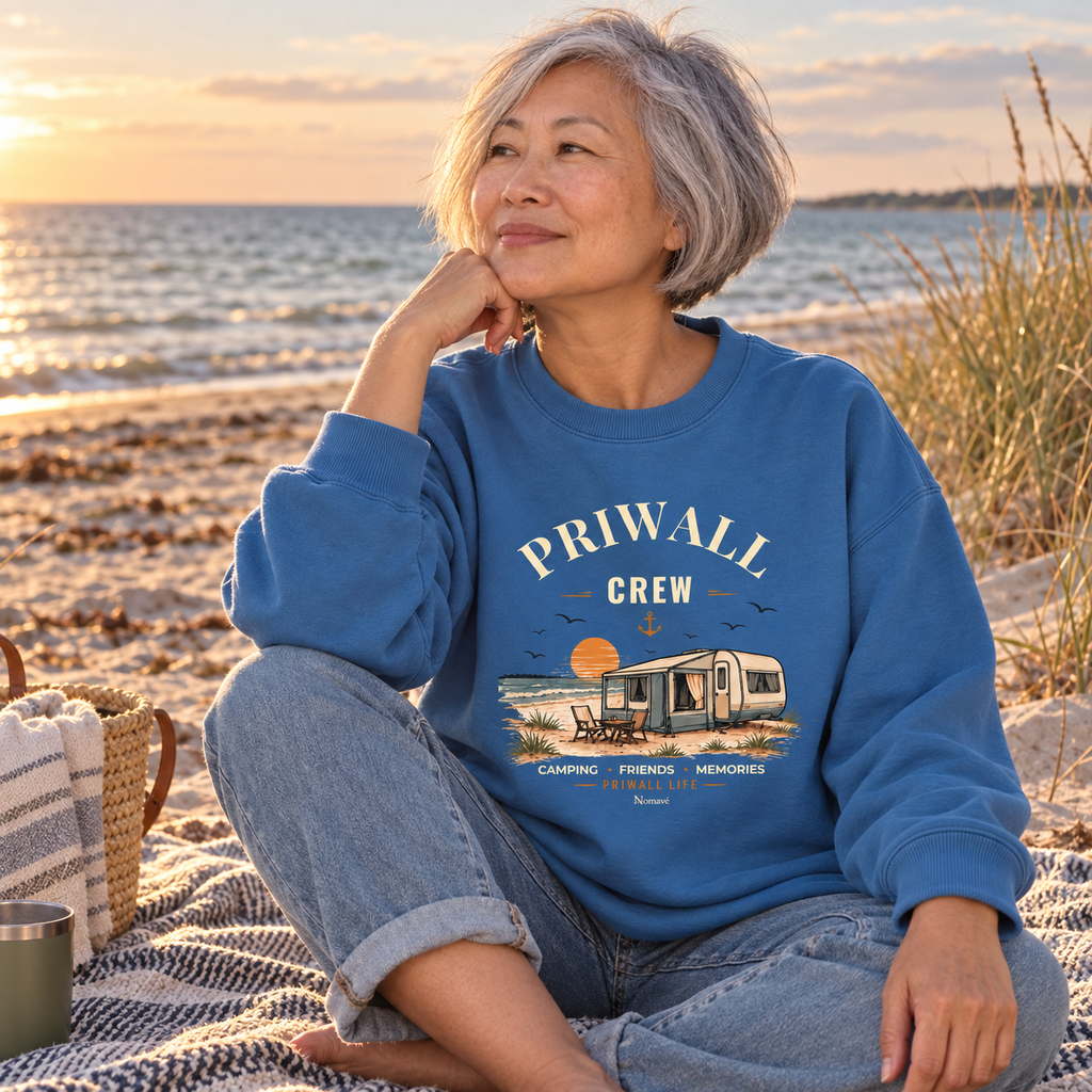 Frau im mindful-blauen Bio Oversize Sweatshirt mit Priwall-Crew-Motiv am Ostseestrand
