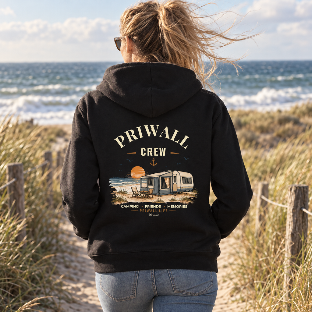 Frau im schwarzen Bio-Zipper mit Priwall-Crew-Backprint auf einem Küstenweg an der Ostsee