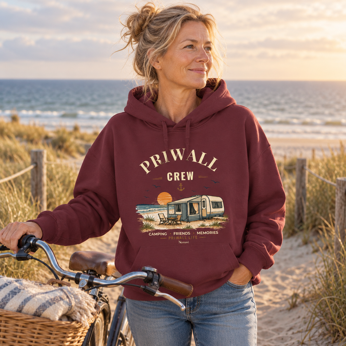 Frau im burgunderfarbenen Damen Bio Boxcut Hoodie mit Priwall-Crew-Motiv am Dünenzugang