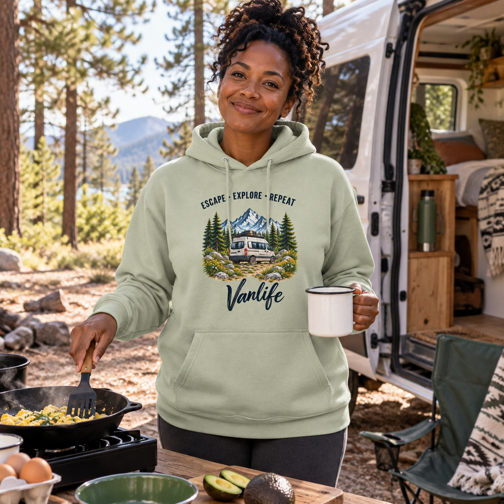 Frau im Aloe Escape Explore Repeat Vanlife Bio-Hoodie beim Campingfrühstück