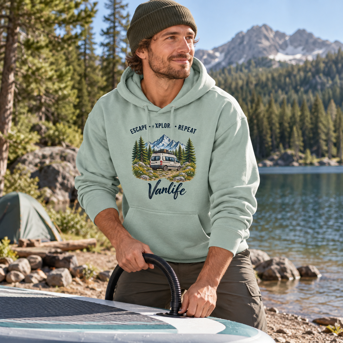 Mann im Misty Jade Escape Explore Repeat Vanlife Oversize-Hoodie am Waldsee