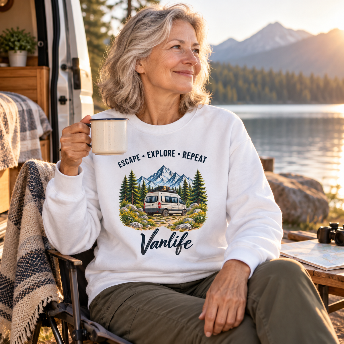 Frau im weißen Escape Explore Repeat Vanlife Bio-Sweatshirt am Bergsee