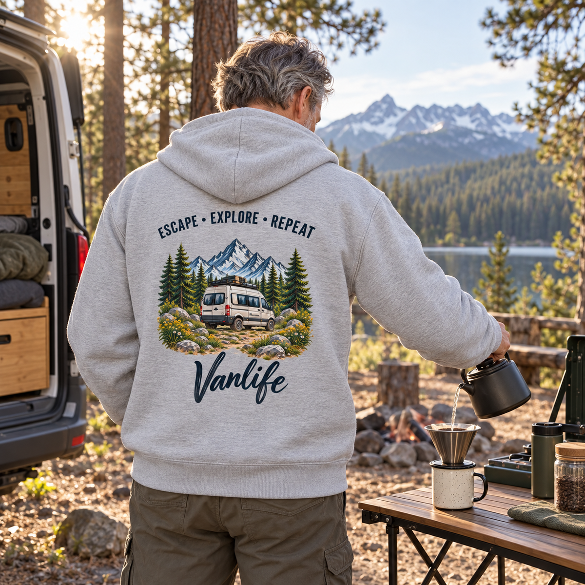 Mann im Heather Grey Escape Explore Repeat Vanlife Bio-Zipper mit Backprint beim Camping