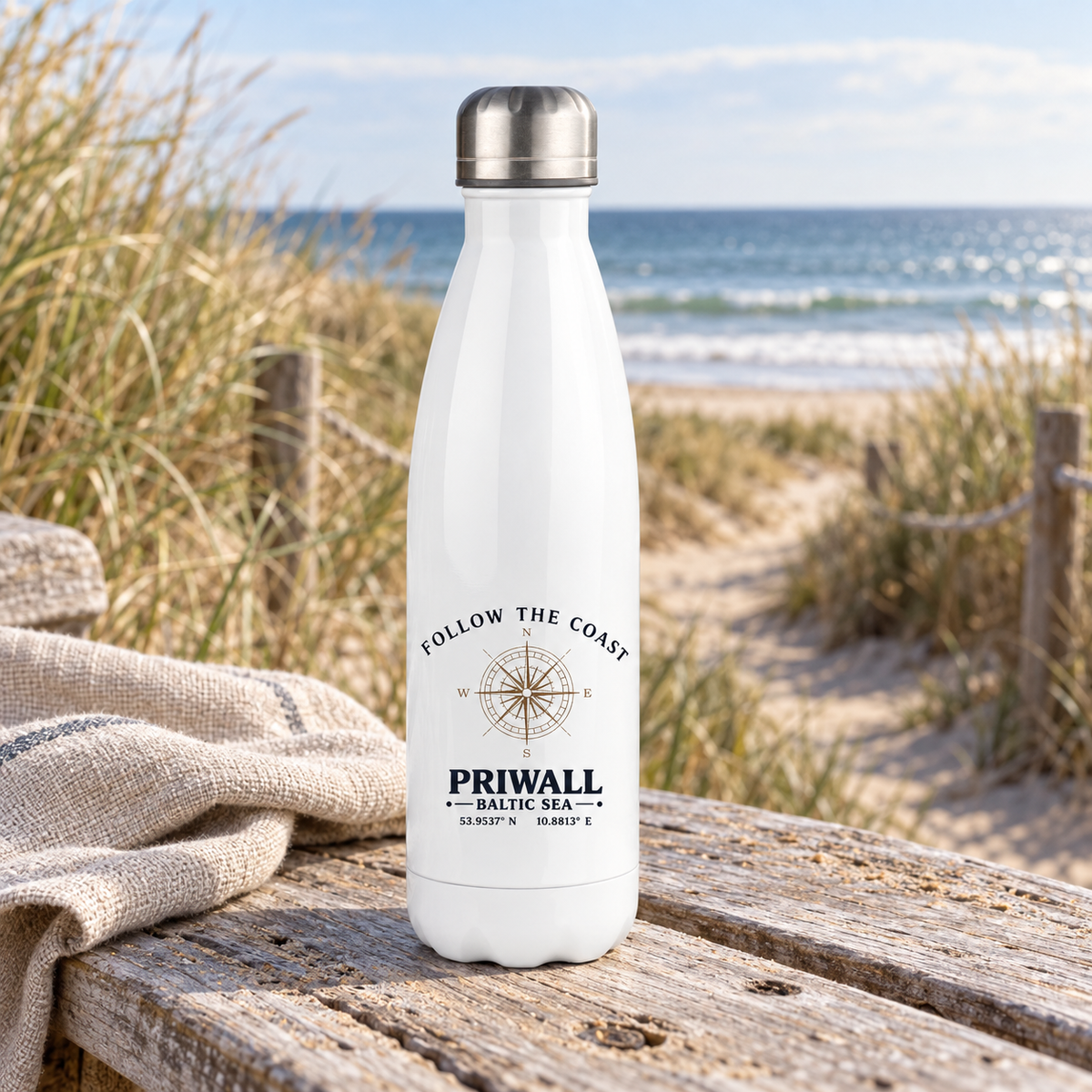 Weiße Follow the Coast Priwall Thermoflasche mit Kompassmotiv am Ostseestrand