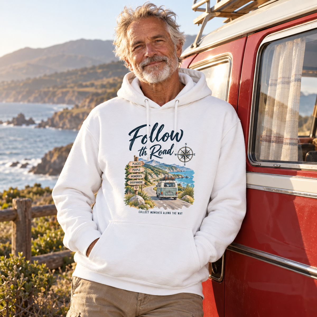 Älterer Mann im weißen Bio Hoodie mit Follow the Road Motiv neben einem roten Vintage-Camper