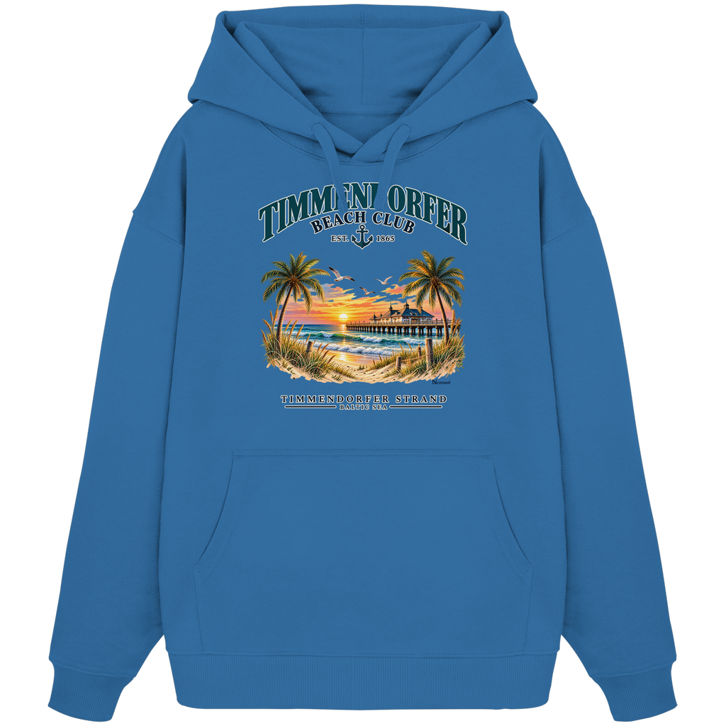 Originalmockup: Timmendorfer Beach Club Unisex Bio-Oversize-Hoodie in Mindful Blue, Vorderansicht mit maritimem Frontprint, Palmen, Seebrücke und Meer.