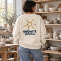 Grömitz Sonne Bio Oversize Sweatshirt Natural Raw mit Rückendruck – Frau in einer Keramikwerkstatt, KI-Produktvisualisierung