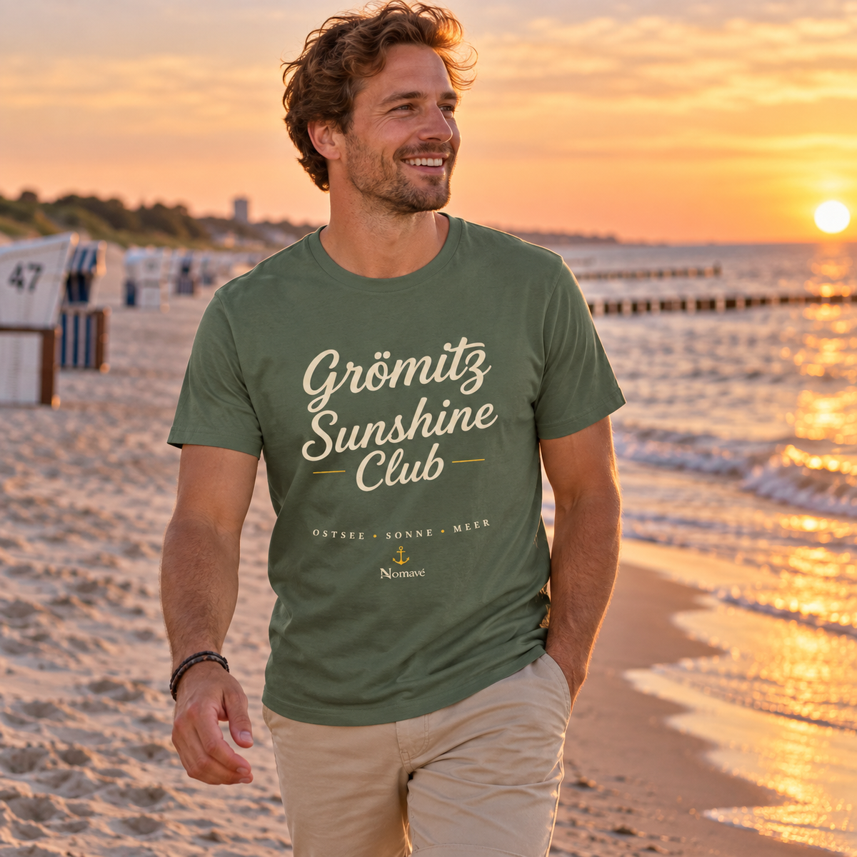 Mann im Grömitz Sunshine Club Dark Essential T-Shirt am Ostseestrand