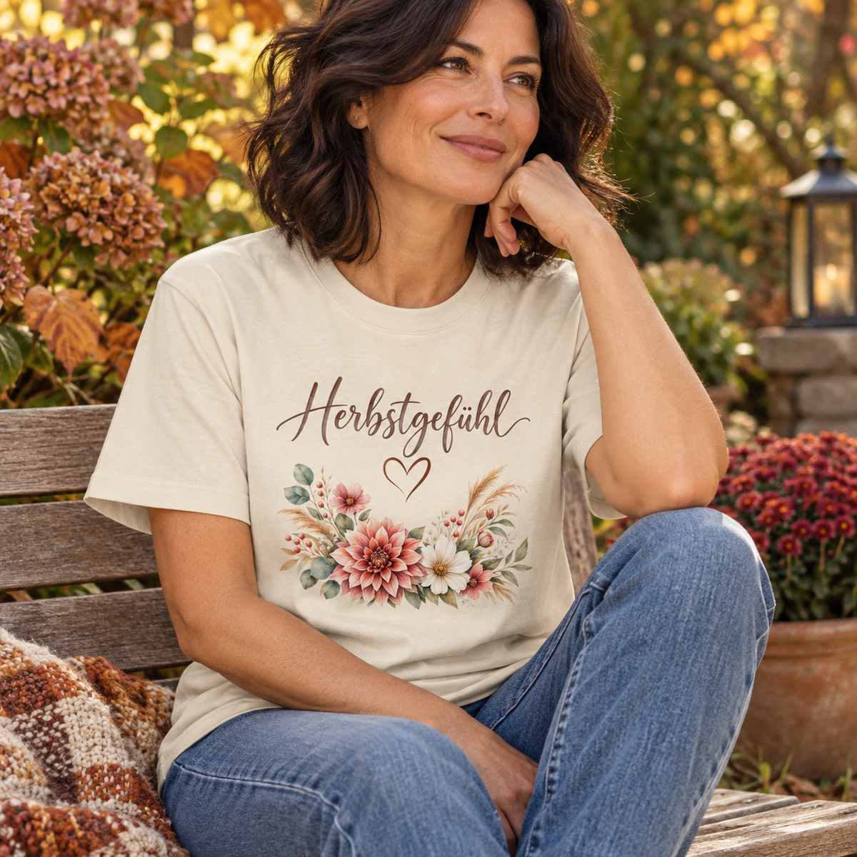 Frau trägt Herbstgefühl Autumn Bloom Bio-Heavy T-Shirt auf einer Gartenbank im Herbst
