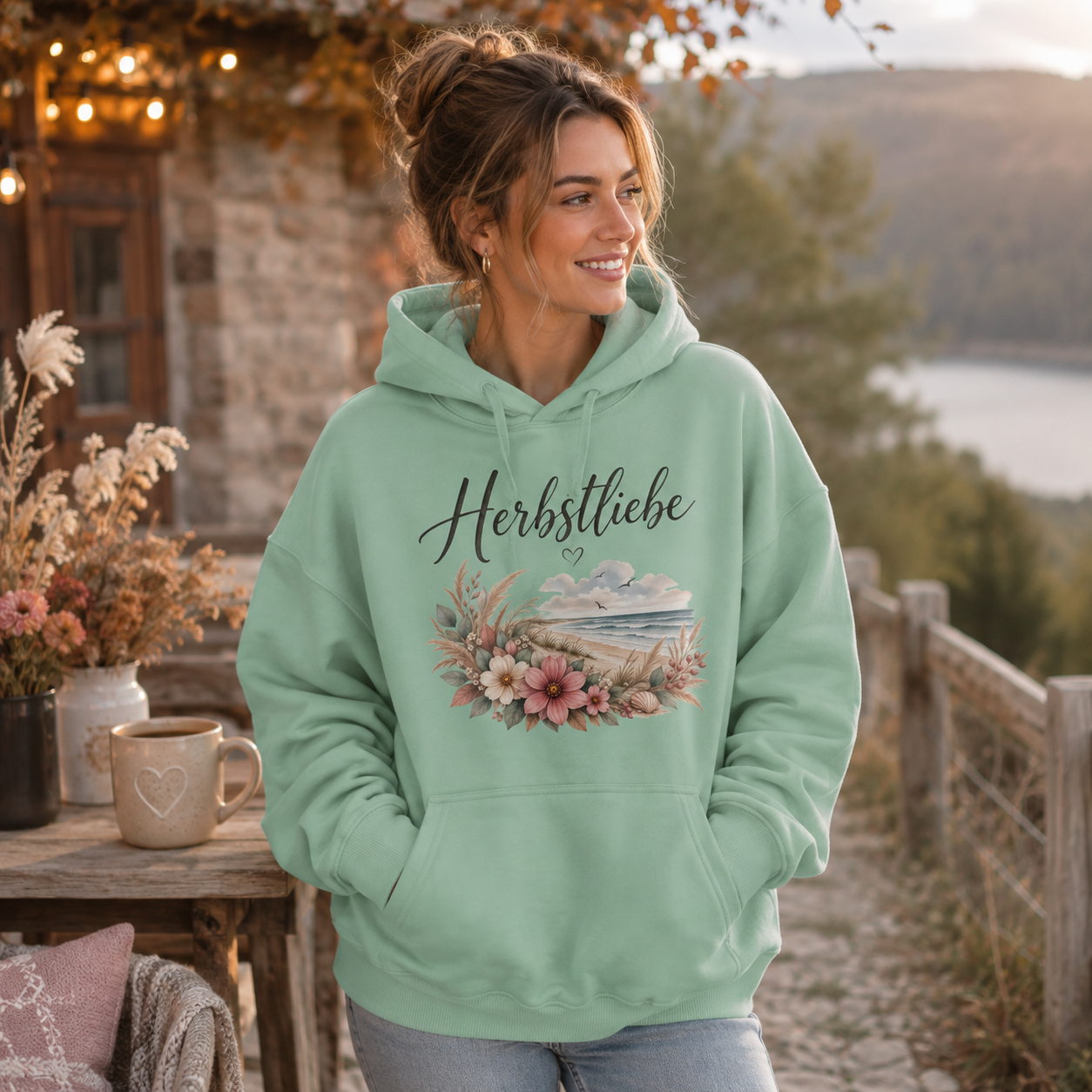 Junge Frau im mintgrünen Herbstliebe Oversize Hoodie – florales Küstenmotiv der Autumn Coast Kollektion
