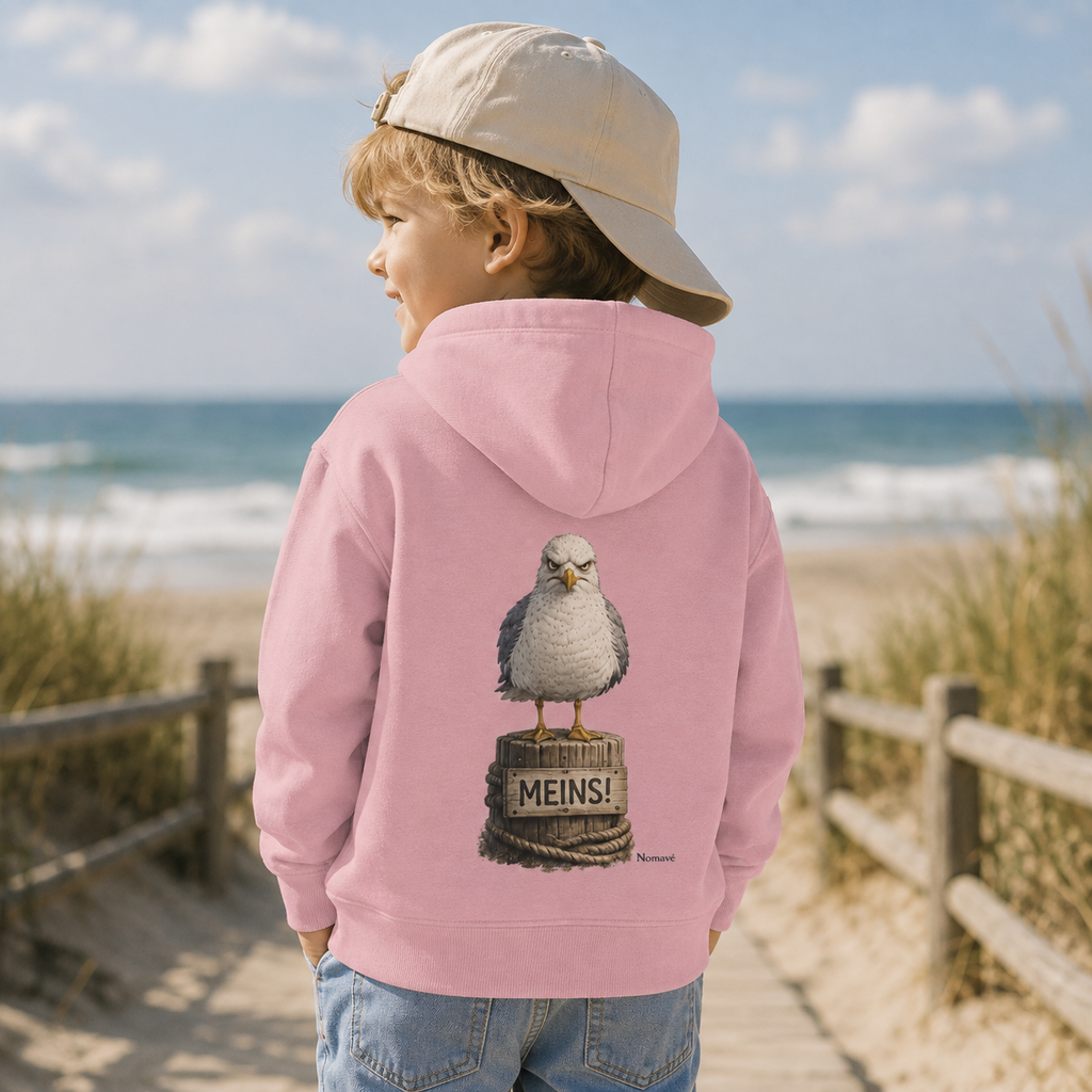 Kind trägt einen rosa Bio-Kinderhoodie von Nomavé mit dem Rückenmotiv „Möwe mit Meinung – MEINS!“ und blickt auf einem Strandweg an der Ostsee in Richtung Meer.