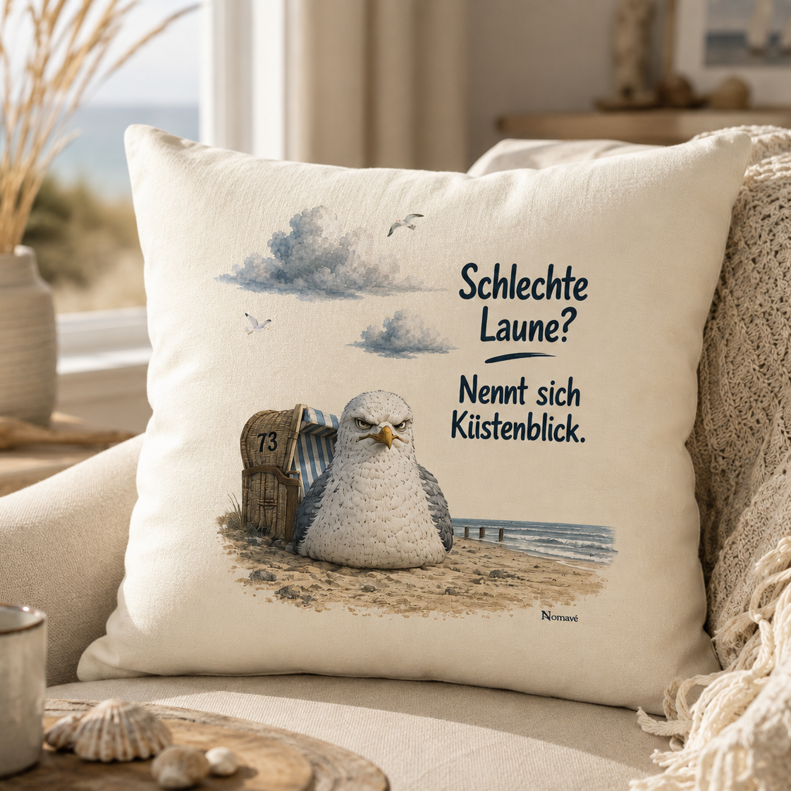 Maritimes Dekokissen von Nomavé mit dem Motiv „Schlechte Laune? Nennt sich Küstenblick.“ und der grimmigen Möwe Alpha in einem gemütlichen Wohnbereich mit Blick auf die Ostsee.