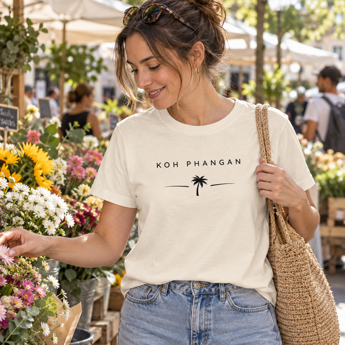 Frau im Damen Bio T-Shirt mit Koh Phangan Minimal Palm Frontprint auf einem Blumenmarkt
