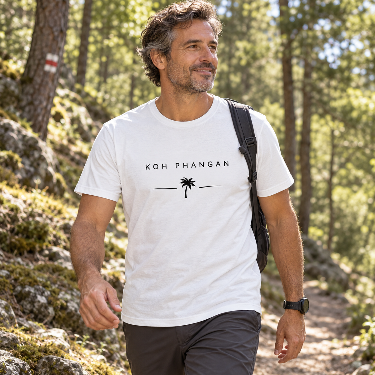 Mann im Essential T-Shirt mit Koh Phangan Minimal Palm Motiv bei einer Waldwanderung