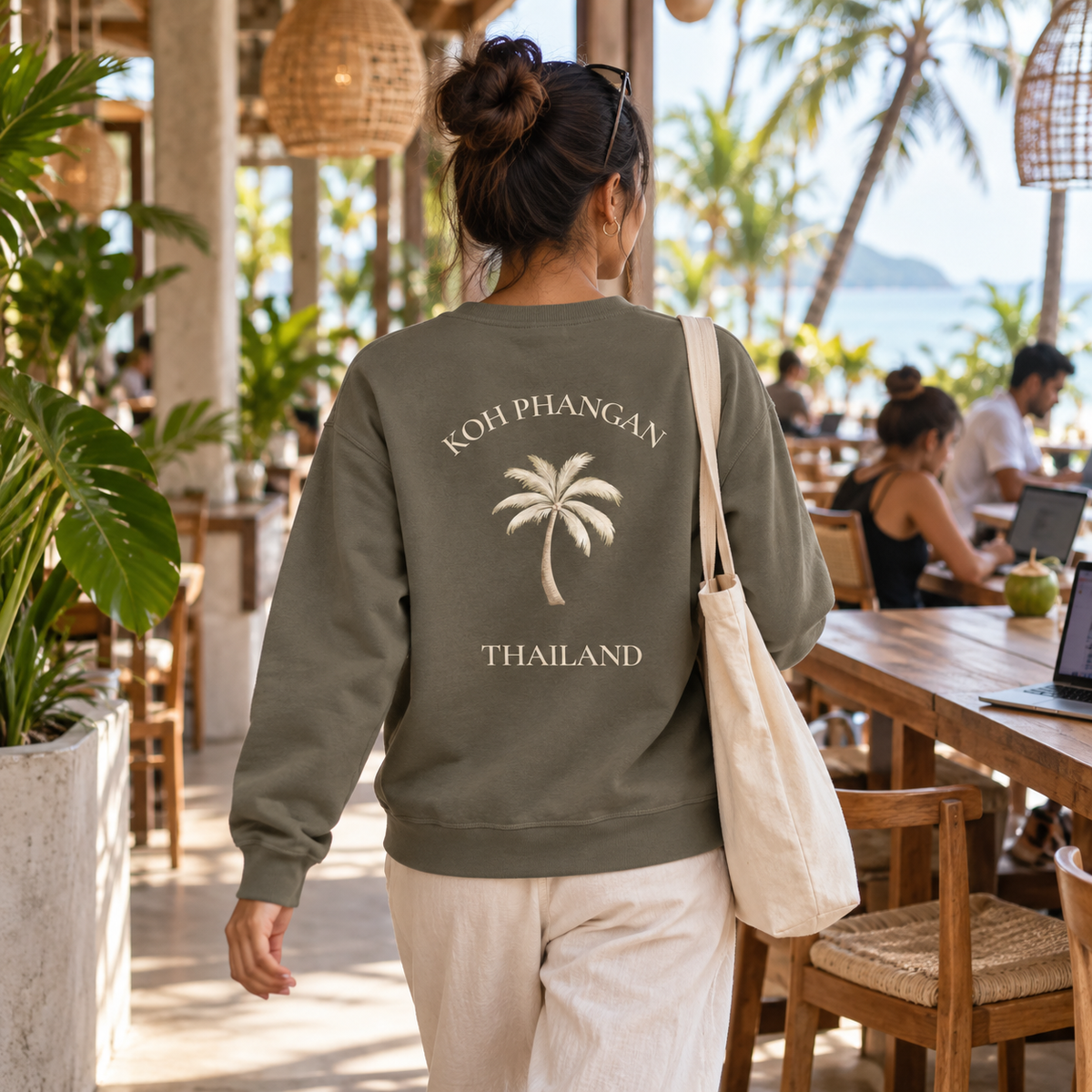Bio Unisex Sweatshirt mit Koh Phangan Mini Palm Rückenmotiv in einem modernen thailändischen Café