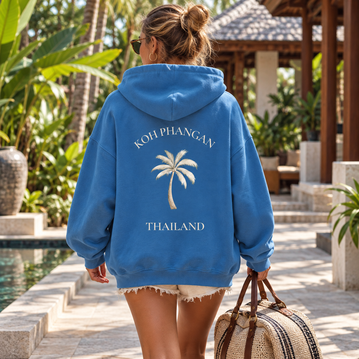 Bio Oversize Hoodie mit Koh Phangan Mini Palm Rückenmotiv in einem tropischen Hotelhof
