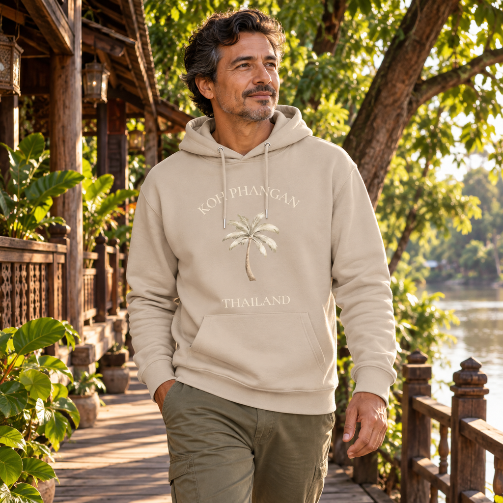Mann im Desert Dust Bio Hoodie mit Koh Phangan Mini Palm Frontprint am thailändischen Flussufer