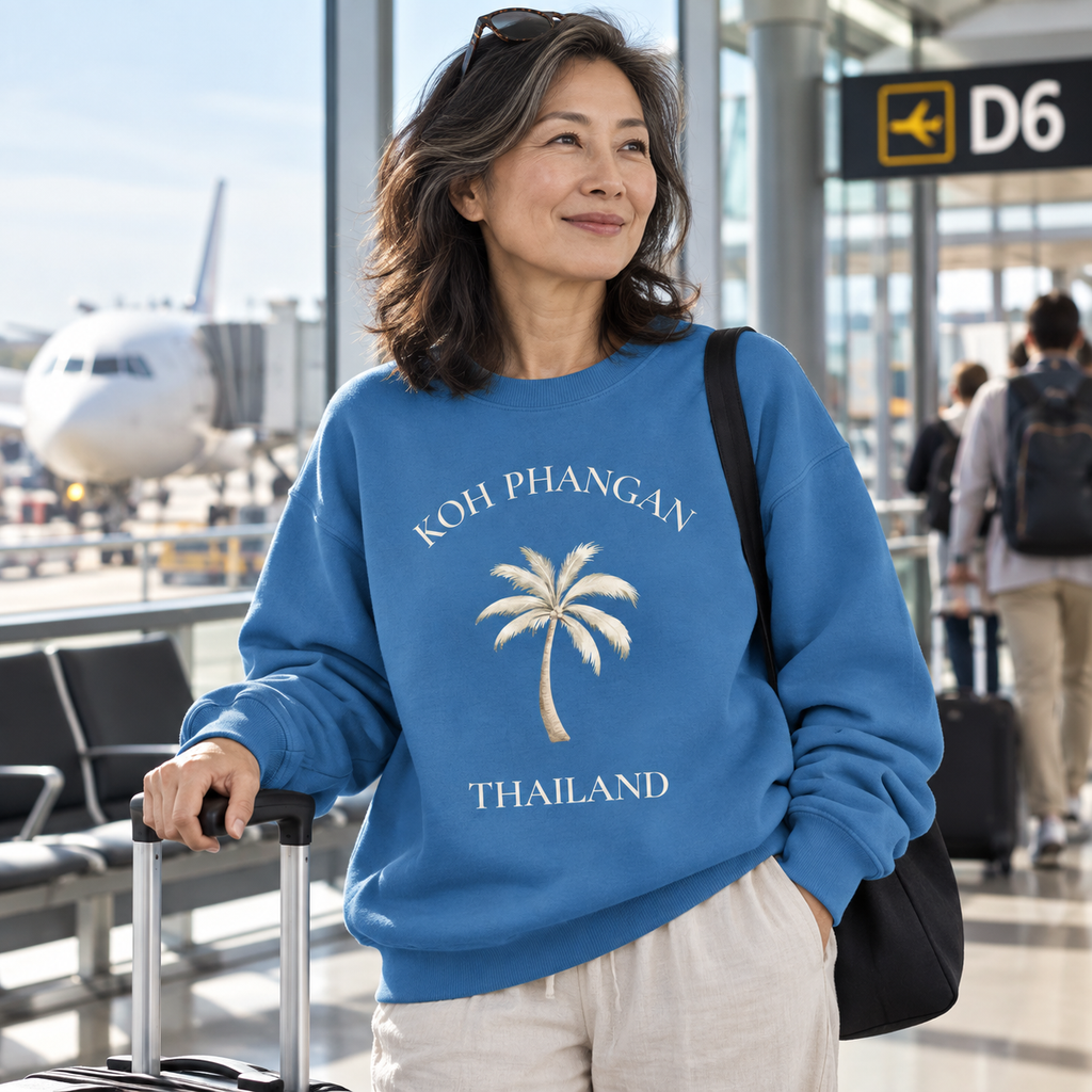 Frau im Mindful Blue Bio Oversize Sweatshirt mit Koh Phangan Mini Palm Frontprint am Flughafen