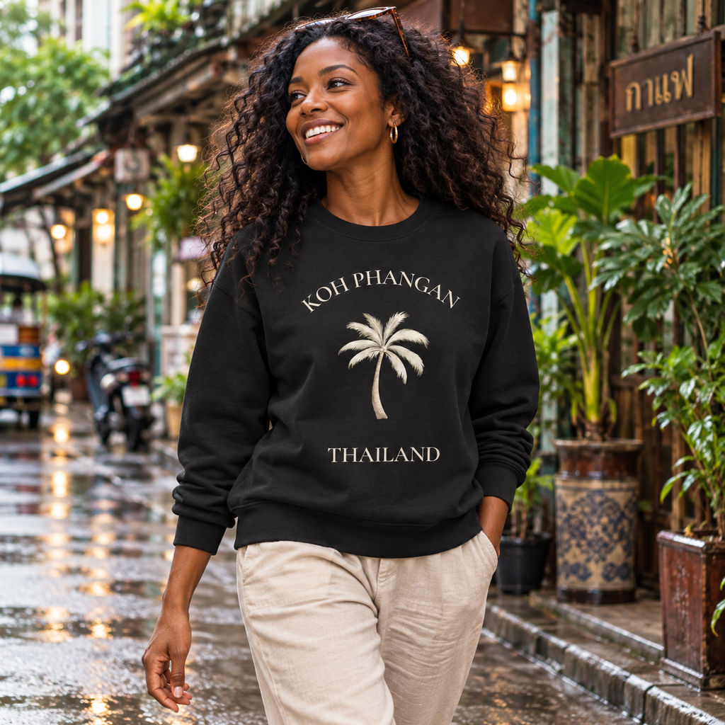 Frau in schwarzem Bio Unisex Sweatshirt mit Koh Phangan Mini Palm Frontprint auf einer Straße in Bangkok