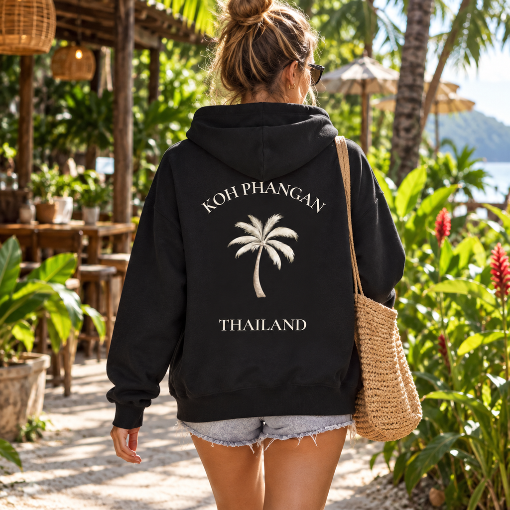 Frau mit schwarzer Bio Zipper Kapuzenjacke und Koh Phangan Mini Palm Backprint in einem thailändischen Garten