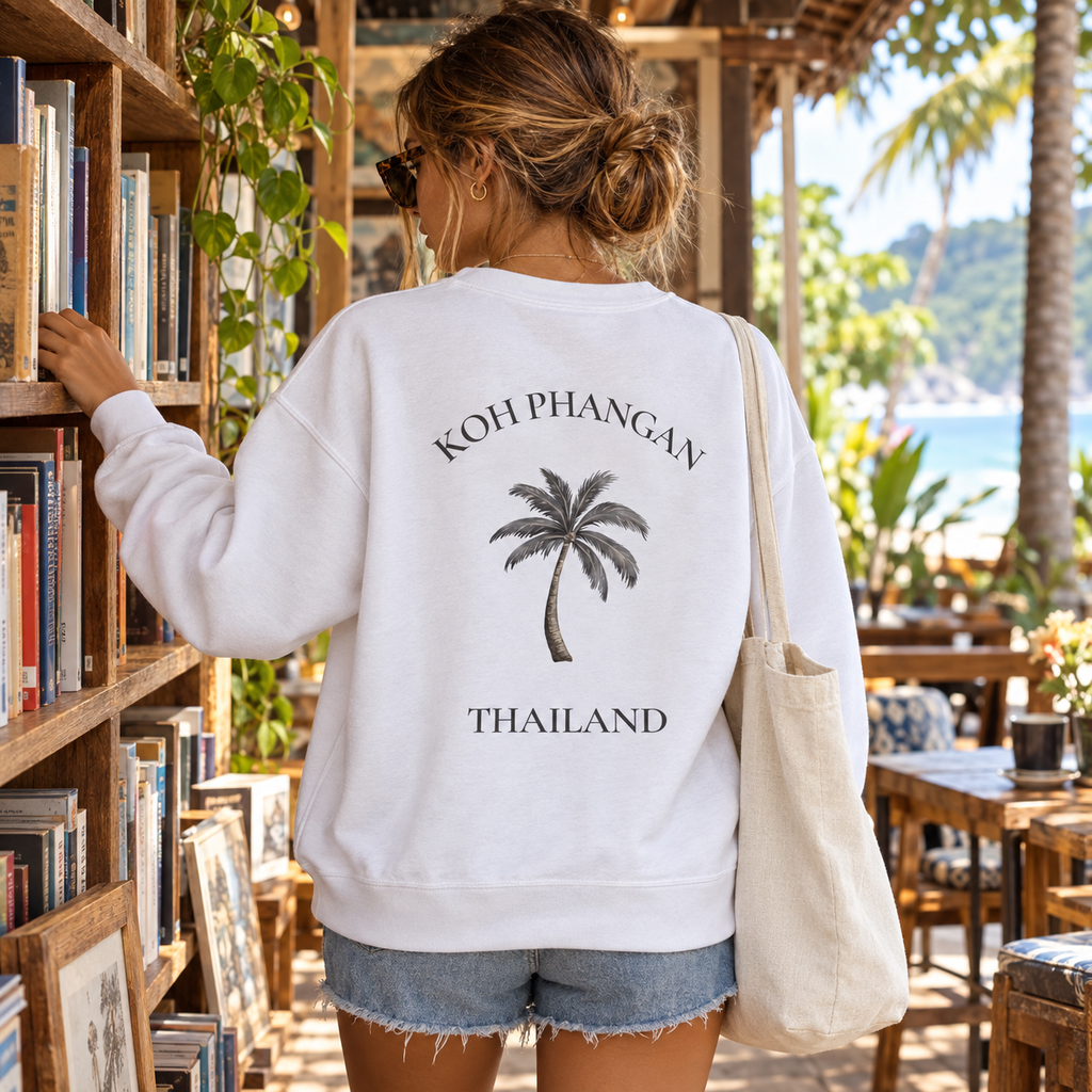 Bio Unisex Sweatshirt in Weiß mit Koh Phangan Mini Palm Backprint in einem thailändischen Büchercafé