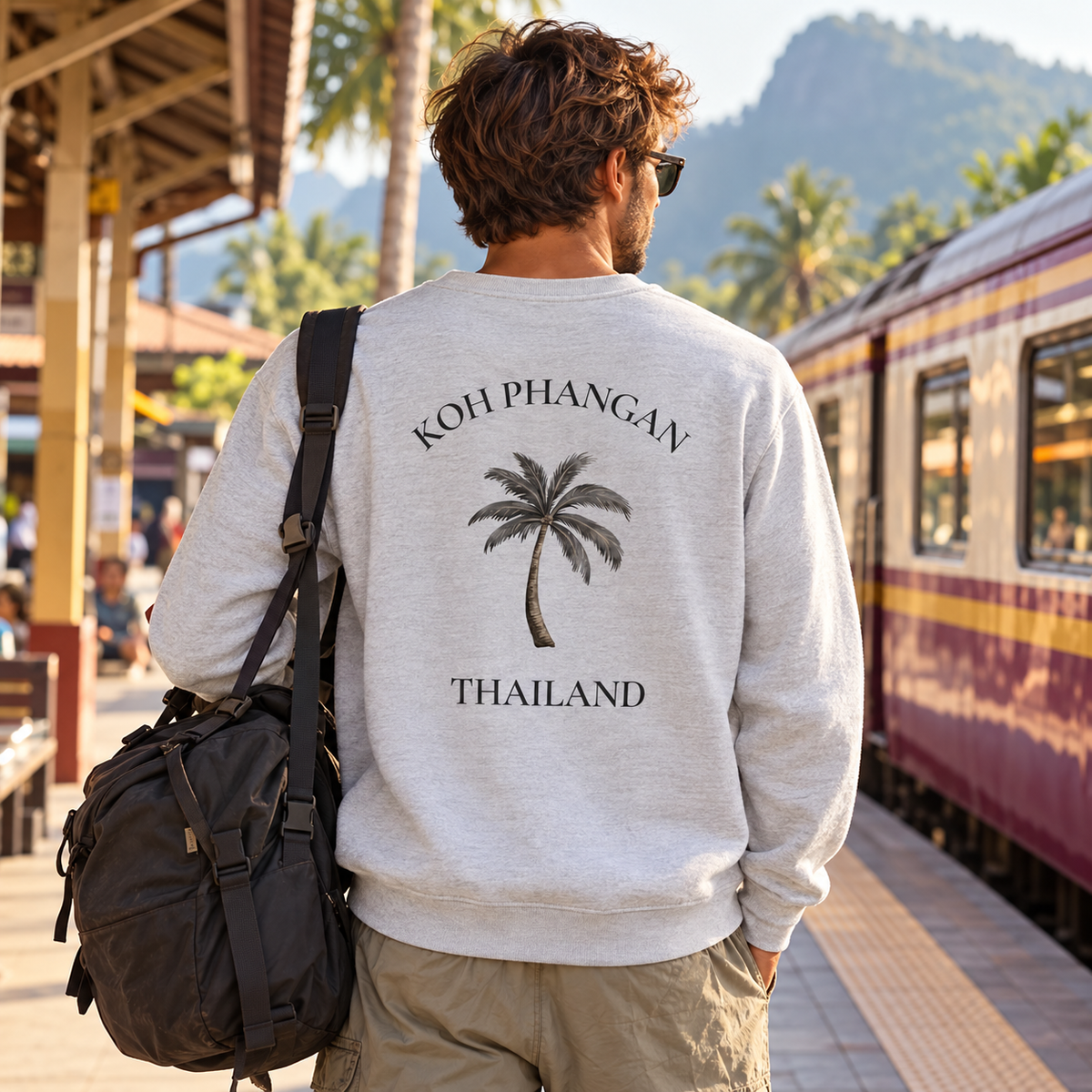 Bio Unisex Sweatshirt in Heather Grey mit Koh Phangan Mini Palm Rückenprint an einem thailändischen Bahnhof
