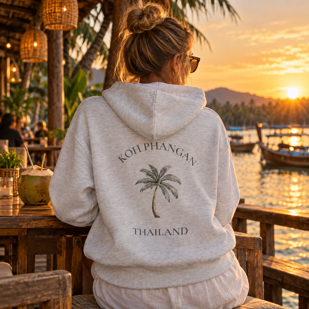 Bio Side Pocket Hoodie in Weiß mit Koh Phangan Mini Palm Rückenmotiv in einem Restaurant am Wasser