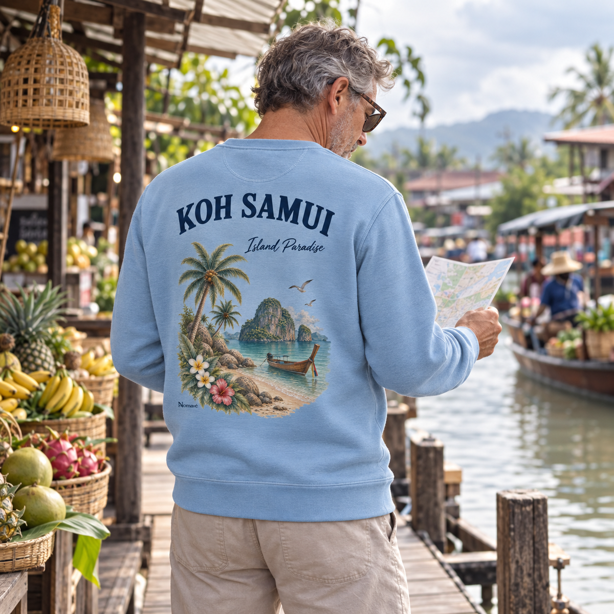 Mann im Serene-Blue Bio Sweatshirt mit Koh Samui Island Paradise Rückenprint an einem Markt-Anleger