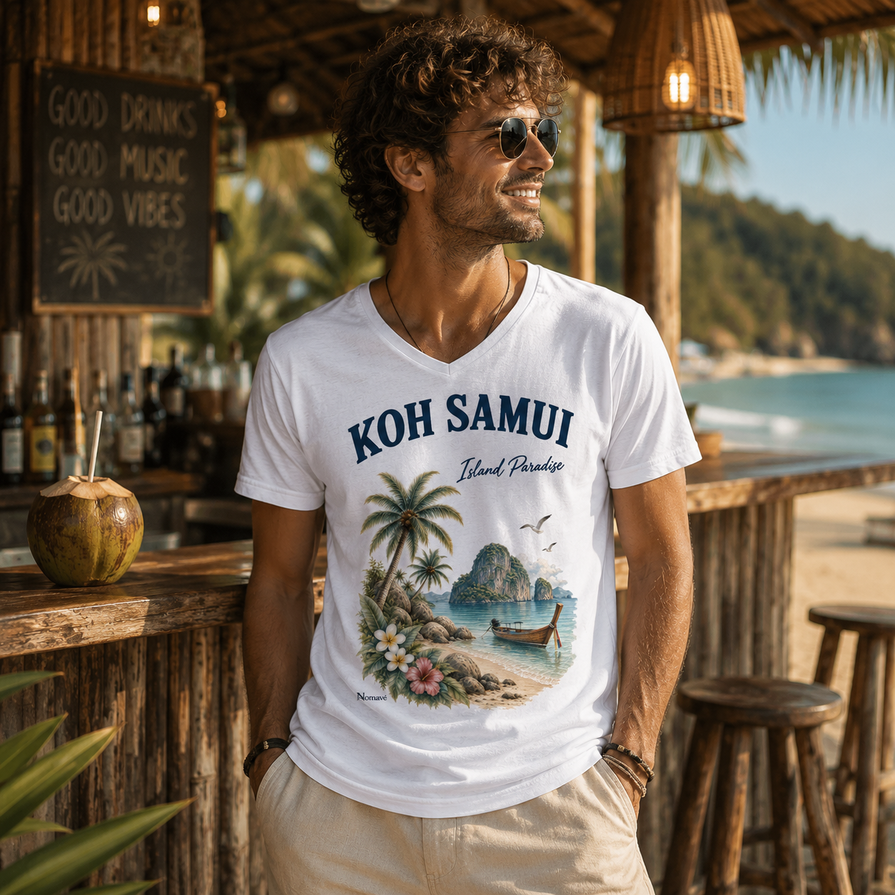 Junger Mann trägt weißes Koh Samui Island Paradise V-Neck T-Shirt mit tropischem Vintage-Motiv an einer Beachbar.