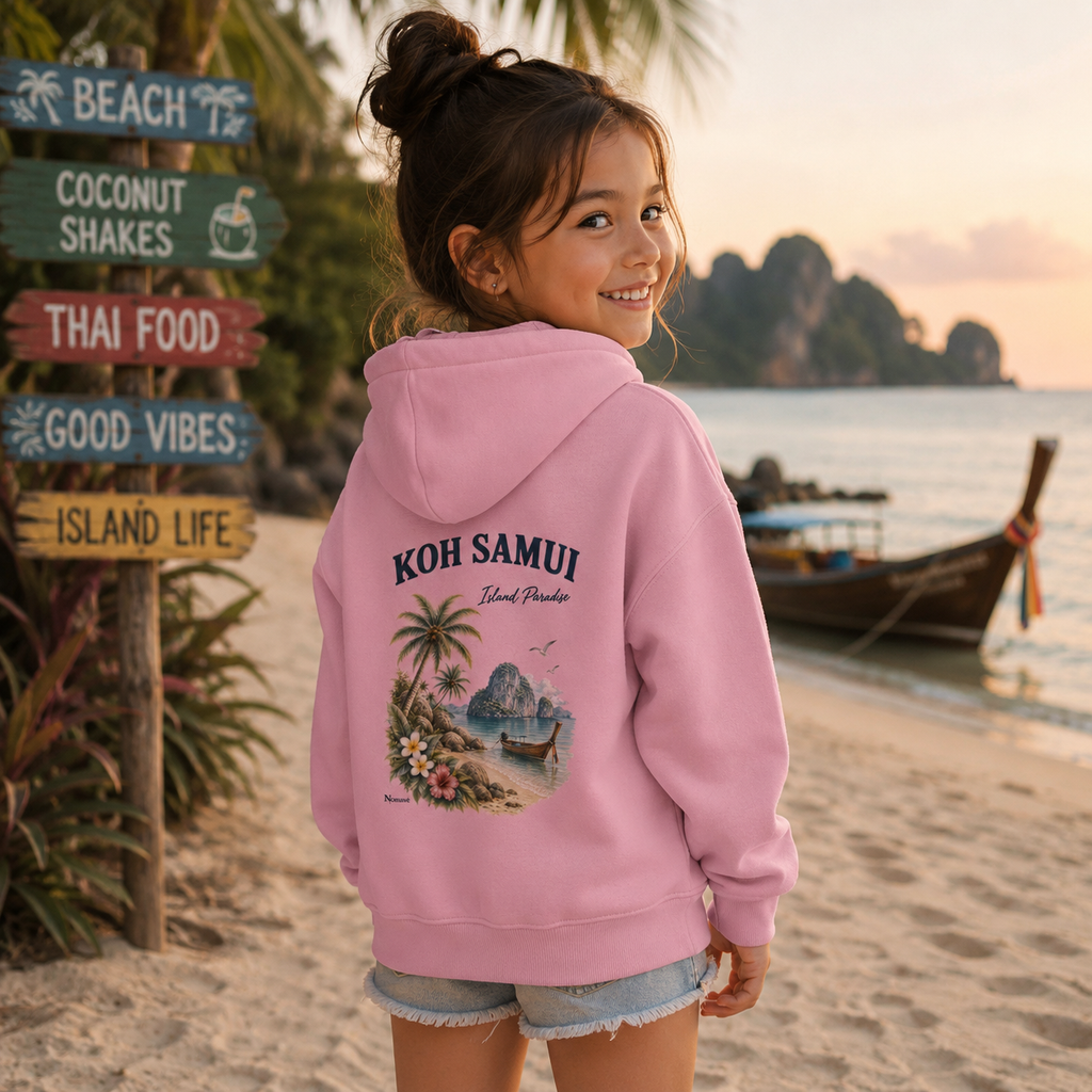 Mädchen trägt einen rosa Koh Samui Island Paradise Kinder Hoodie von Nomavé mit Rückenprint am tropischen Strand in Thailand.