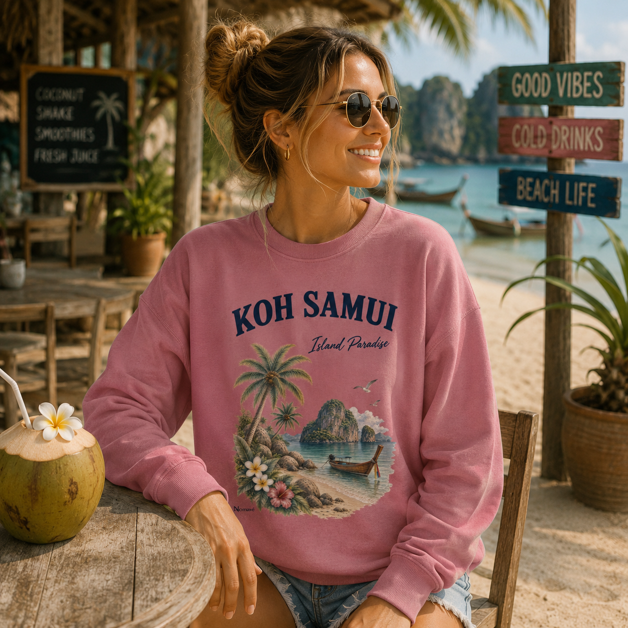 Frau im dunkelrosa Koh Samui Island Paradise Sweatshirt von Nomavé in einem tropischen Strandcafé in Thailand