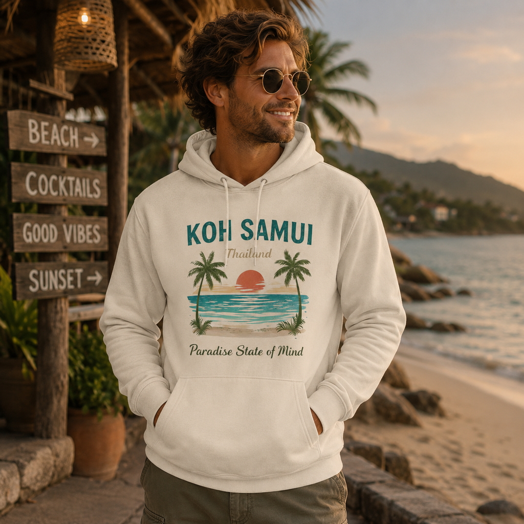 Mann trägt einen naturweißen Bio Hoodie mit Koh Samui Thailand Motiv an einem tropischen Strand mit Palmen und warmem Abendlicht.