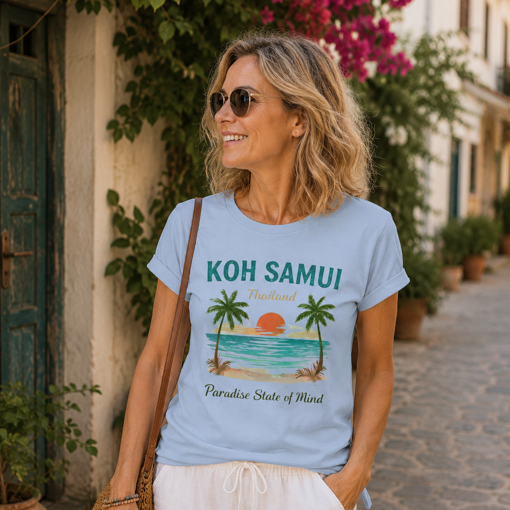 Frau mittleren Alters trägt ein hellblaues Bio Lady-Shirt mit Koh Samui Thailand Motiv in einer tropischen Altstadtgasse mit mediterranem Flair.