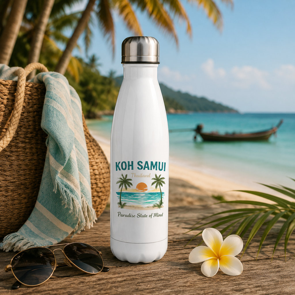 Weiße Edelstahl-Trinkflasche mit Koh Samui Thailand Motiv auf einem Holztisch an einem tropischen Strand mit Palmen, Longtailboot und türkisblauem Meer.