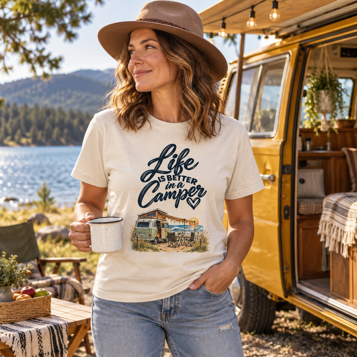 Frau im naturfarbenen Bio-Heavy-Shirt mit Camper-Motiv beim Picknick vor senfgelbem Vintage-Camper am See