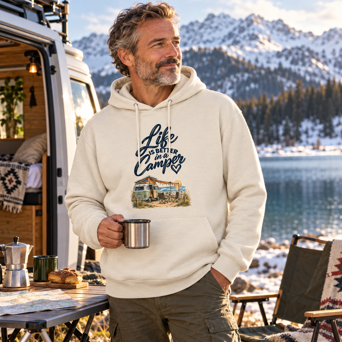 Mann im Bio-Hoodie mit Camper-Motiv an einem winterlichen Bergsee