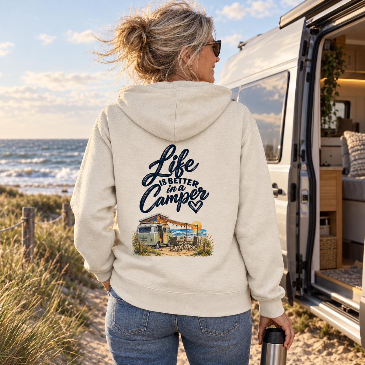 Frau mit Bio-Zipper und Life-is-better-in-a-Camper-Rückendruck am Ostseestrand