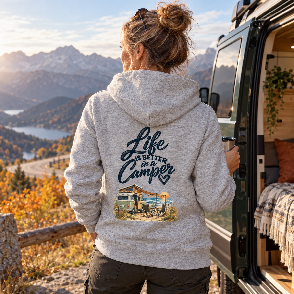 Frau im Heather-Grey Bio-Zipper mit Life-is-better-in-a-Camper-Rückendruck am herbstlichen Bergpass