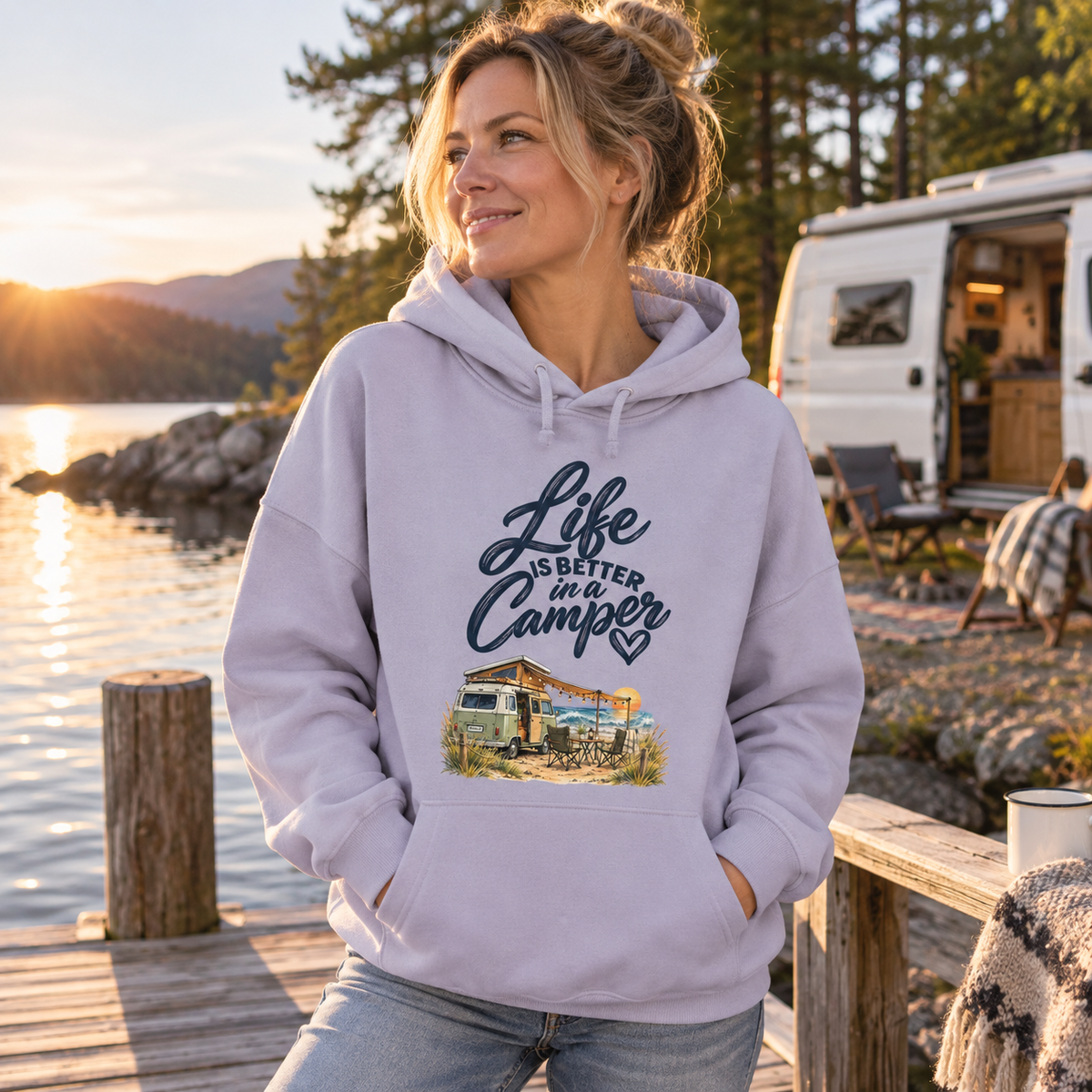 Frau im lavendelfarbenen Damen Bio-Boxcut-Hoodie mit Camper-Motiv auf einem skandinavischen Holzsteg