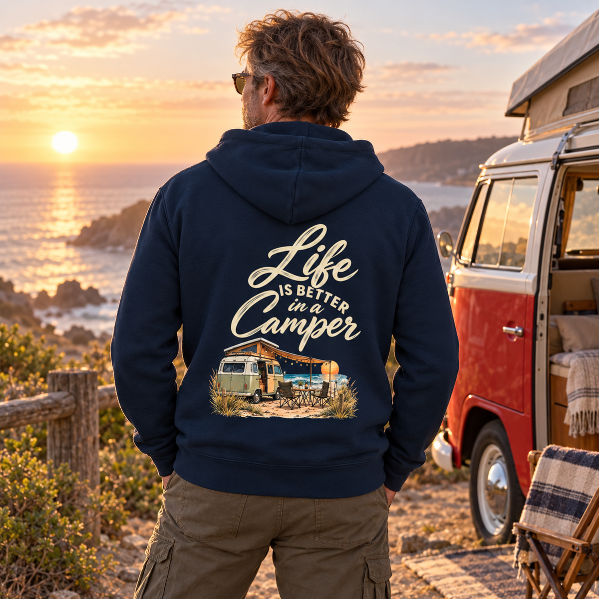 Bio Zipper in French Navy mit Life is better in a Camper Rückendruck am Meer vor rot-weißem Vintage-Camper
