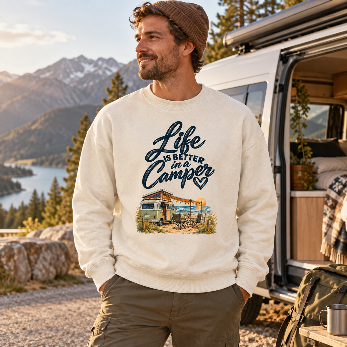 Mann im Bio-Oversize-Sweatshirt mit Camper-Motiv bei einer Berg-Roadtrip-Pause