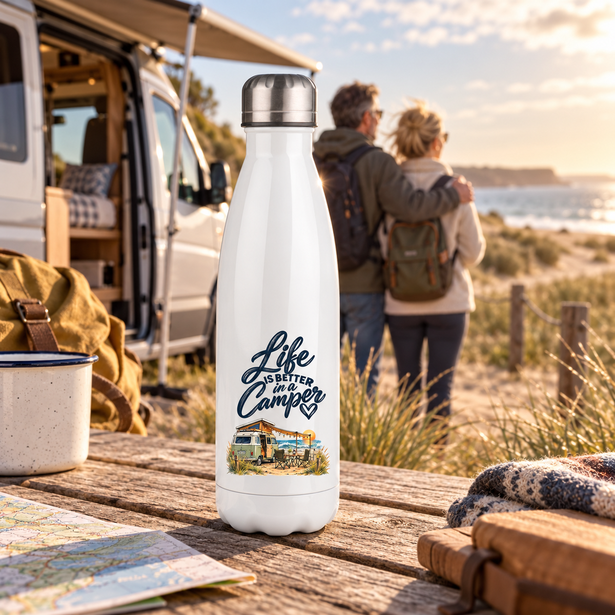 Weiße Thermoflasche mit Life-is-better-in-a-Camper-Motiv bei einer Dünenwanderung am Meer