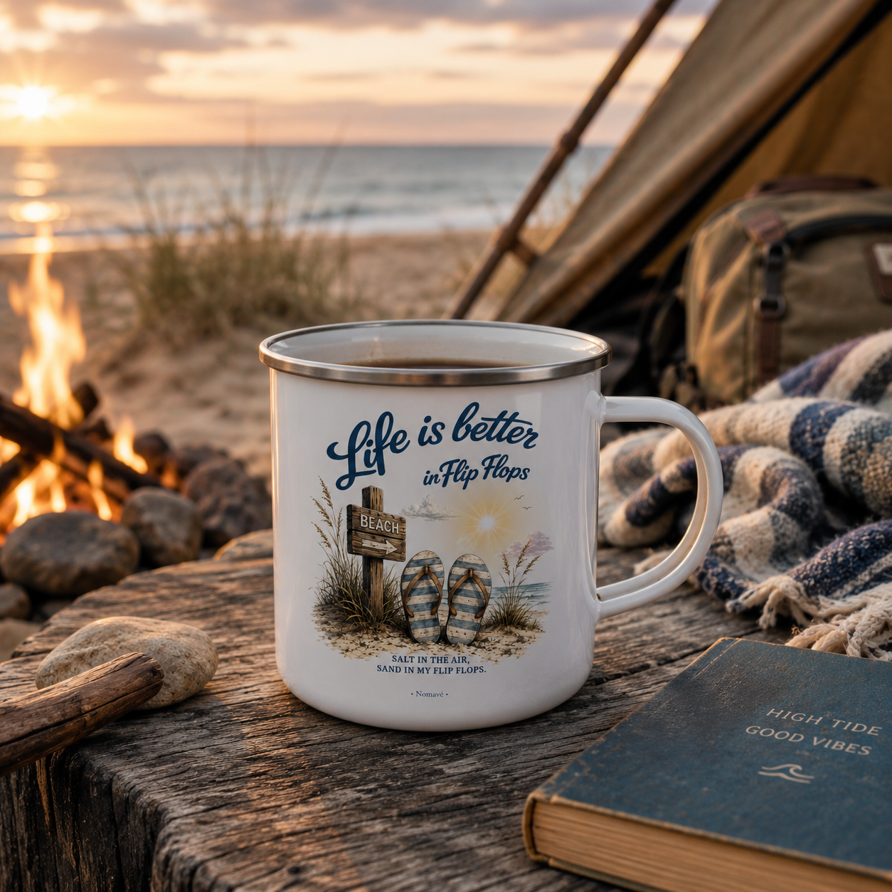 Nomavé Camping-Emaillebecher „Life is Better in Flip Flops“ am Ostseestrand vor einem Zelt und Lagerfeuer im warmen Morgenlicht – maritimer Camping- und Vanlife-Lifestyle.