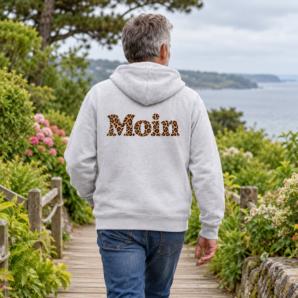 Graue Bio Zipperjacke von hinten mit Moin-Leoprint auf einem Küstengartenweg