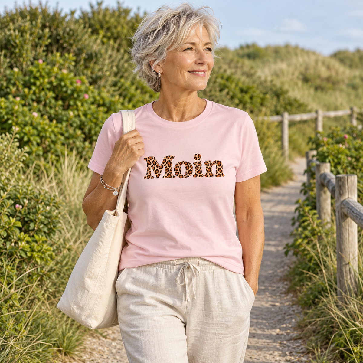 Damen Bio T-Shirt in Cotton Pink mit Moin-Leoprint auf einem grünen Küstenweg