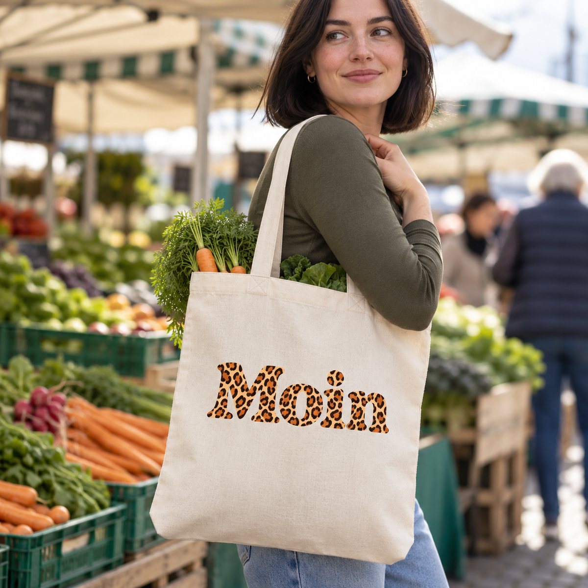 Frau trägt die Tote-Bag in Natural mit Moin-Karamell-Leoprint und Gemüse auf einem Wochenmarkt